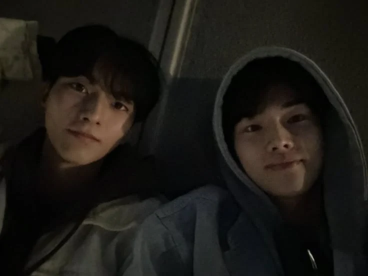 Cassius and Natha taking a selfie with a hooded smile