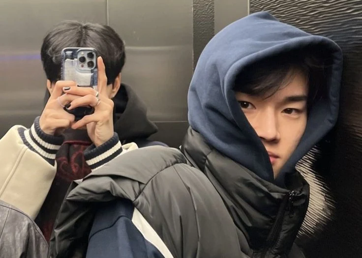 Cassius and Natha bundled up in a lift mirror selfie