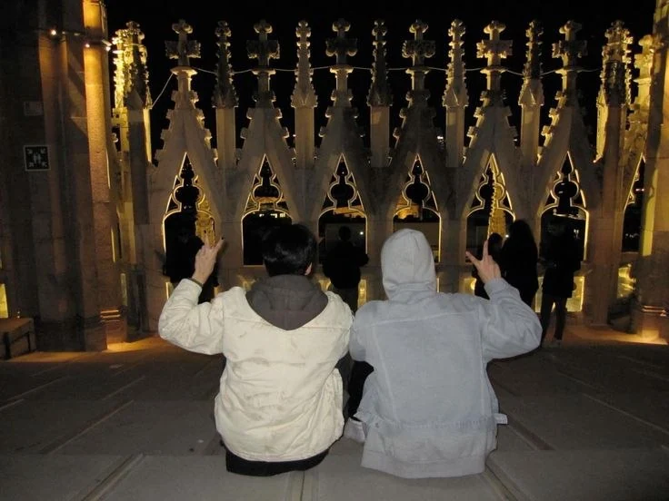 Cassius and Natha seated with their backs to the camera beneath golden lights